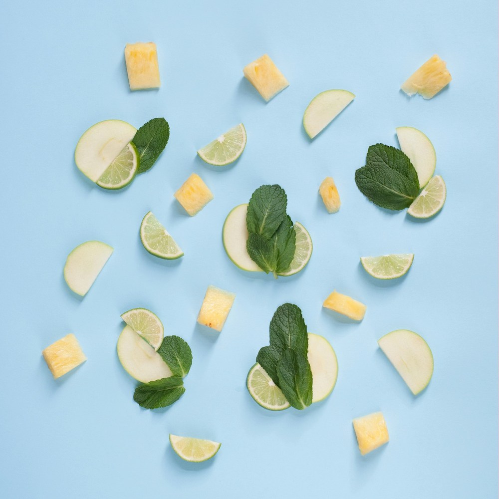 The Importance of Detoxing and Purifying the Body - This images shows slices of apple and lime, chunks of pineapple and mint leaves